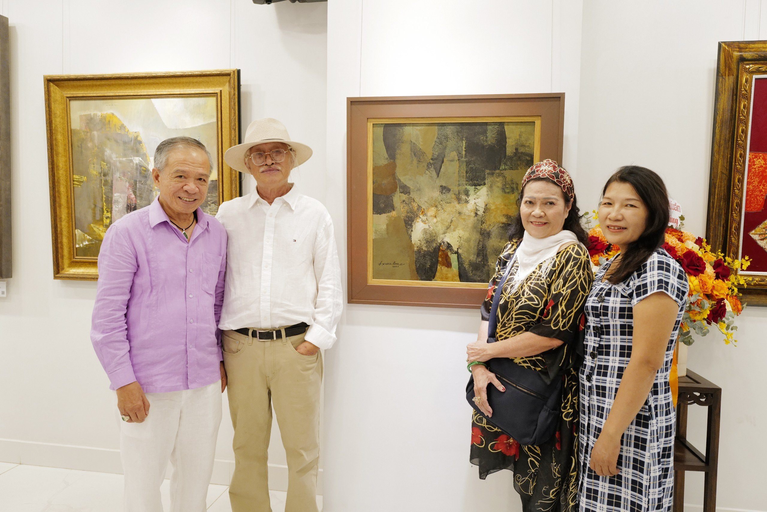 hà sưu tập-Luật sư Trương Văn Thuận, giám đốc Bình Minh Art Gallery chụp hình lưu niệm cùng họa sĩ Đặng Kim Long và các khách mời tại triển lãm - Ảnh: TV